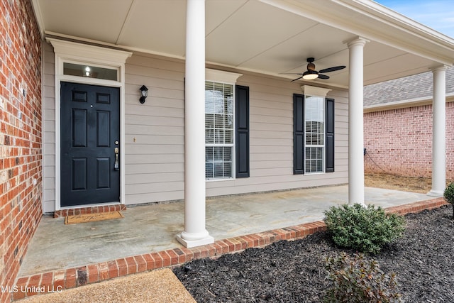 property entrance featuring covered porch, a ceiling fan, and brick siding