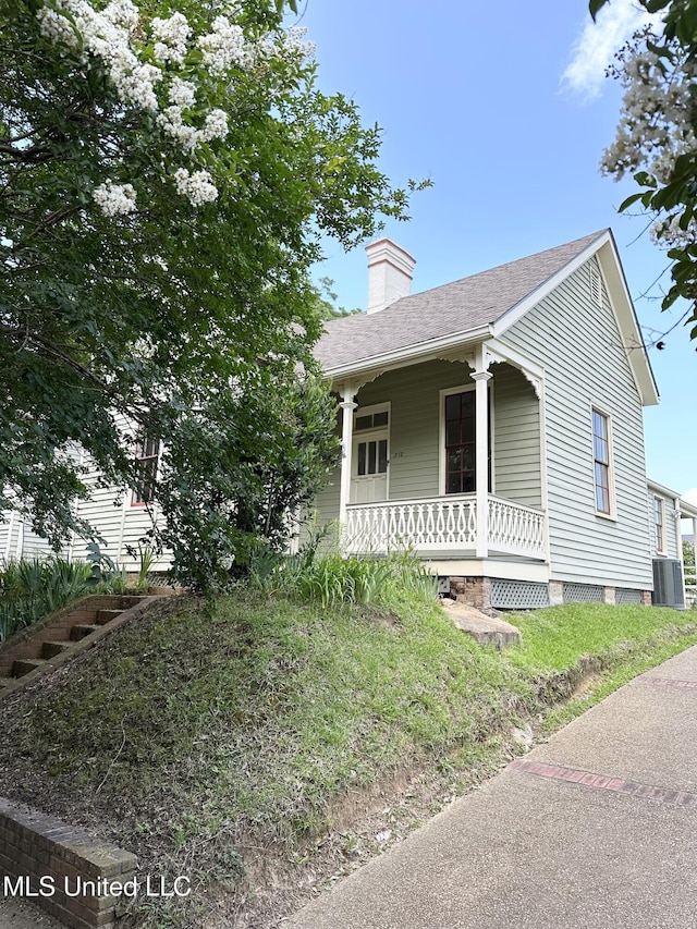 310 N Rankin St, Natchez, MS 39120 - view of front of home featuring a porch, cooling unit, a chimney, and roof with shingles