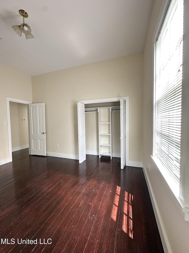 310 N Rankin St, Natchez, MS 39120 - unfurnished bedroom featuring dark wood-style floors, baseboards, and a closet