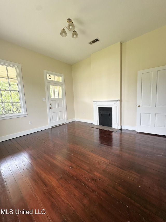 310 N Rankin St, Natchez, MS 39120 - unfurnished living room featuring healthy amount of natural light, a fireplace with flush hearth, wood-type flooring, and baseboards
