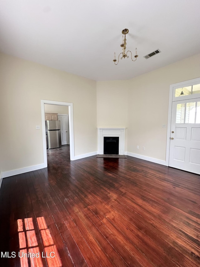 310 N Rankin St, Natchez, MS 39120 - unfurnished living room featuring dark wood-style flooring, a fireplace with flush hearth, a chandelier, and baseboards