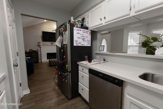 kitchen featuring white cabinetry, a fireplace, stainless steel appliances, and dark hardwood / wood-style floors