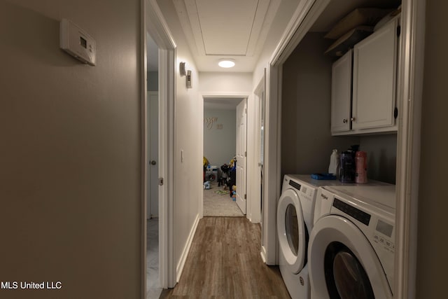 laundry area featuring cabinets, wood-type flooring, and washer and dryer