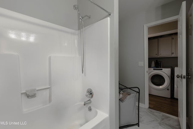 bathroom featuring tub / shower combination and washer / dryer