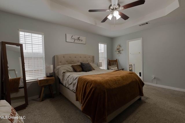 carpeted bedroom with ceiling fan and a tray ceiling