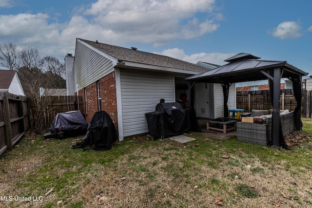 back of house featuring a gazebo, a yard, and an outdoor hangout area