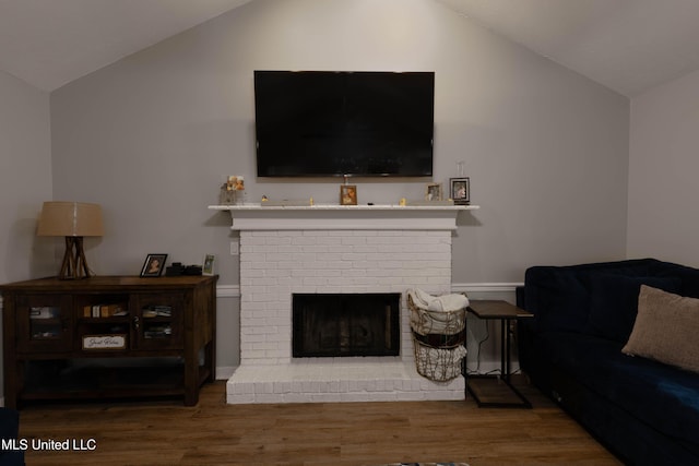 living room with a fireplace, lofted ceiling, and dark hardwood / wood-style flooring