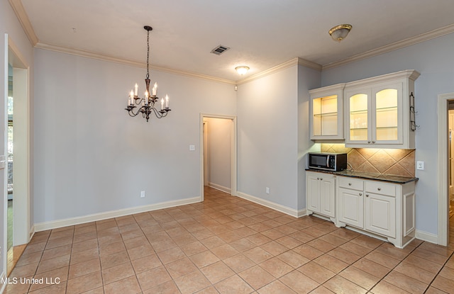 interior space with a healthy amount of sunlight, crown molding, and a notable chandelier