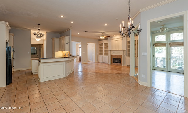 kitchen with light tile patterned flooring, pendant lighting, kitchen peninsula, and ornamental molding