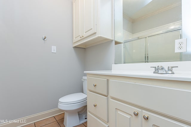 bathroom featuring tile patterned floors, ornamental molding, vanity, toilet, and a shower with shower door