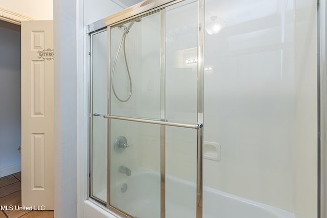 bathroom with shower / bath combination with glass door and wood-type flooring