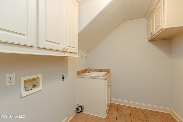 laundry area featuring hookup for an electric dryer, hookup for a washing machine, light tile patterned floors, cabinets, and sink