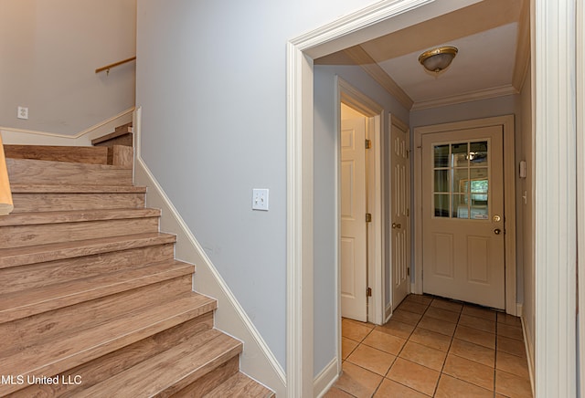 staircase featuring tile patterned flooring and crown molding