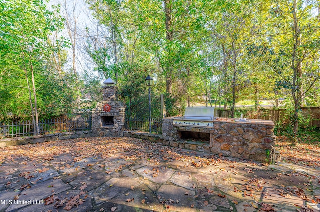 view of patio / terrace with an outdoor kitchen and an outdoor stone fireplace