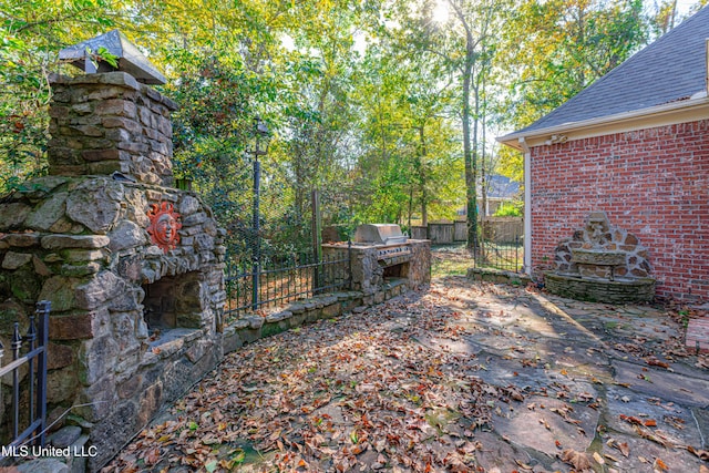 view of yard with exterior kitchen and a fireplace