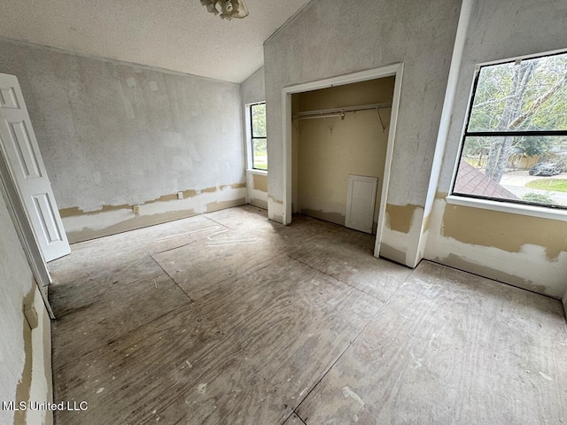 unfurnished bedroom featuring vaulted ceiling and a closet