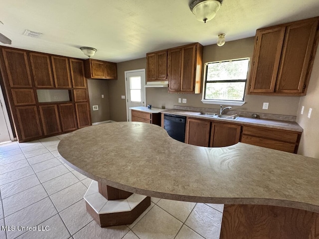 kitchen featuring dishwasher, sink, a healthy amount of sunlight, and light tile patterned floors