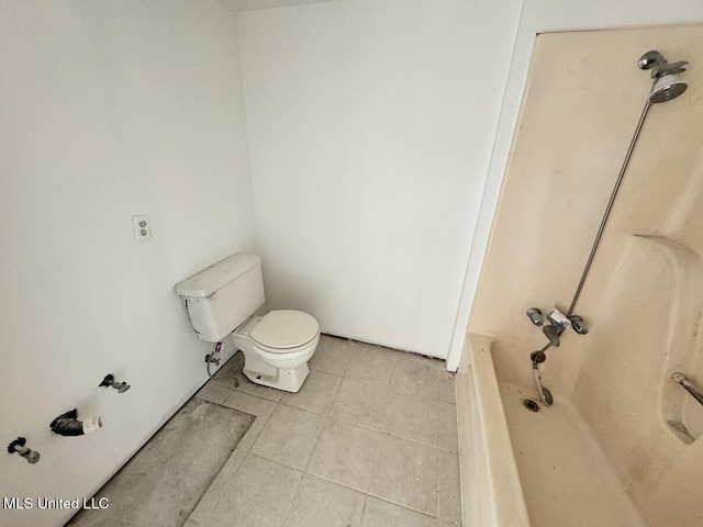 bathroom with tile patterned flooring, a bathtub, and toilet