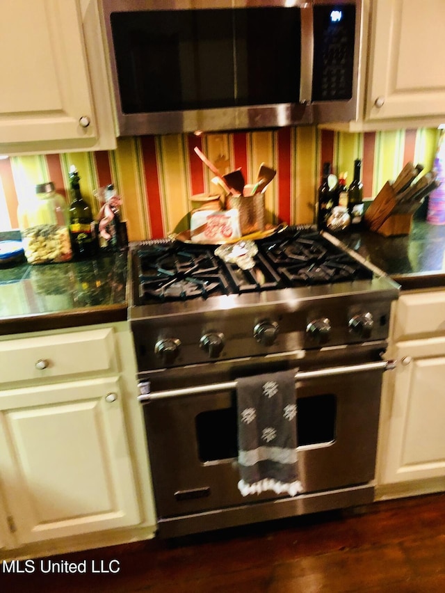 500 Franklin St, Natchez, MS 39120 - kitchen featuring stainless steel appliances, wallpapered walls, dark countertops, and white cabinetry