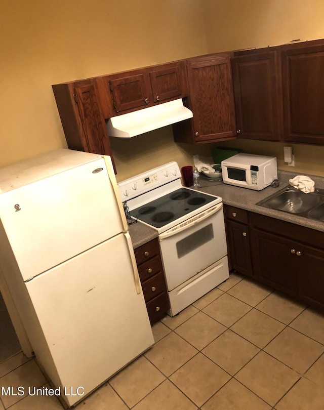 500 Franklin St, Natchez, MS 39120 - kitchen with white appliances, under cabinet range hood, light tile patterned floors, a sink, and dark brown cabinetry