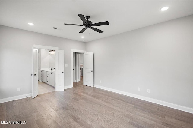 unfurnished bedroom featuring ceiling fan, connected bathroom, and light hardwood / wood-style floors