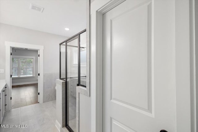 bathroom with vanity and a shower with shower door