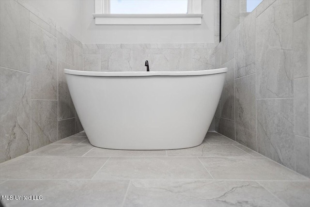 bathroom featuring tile walls and a tub