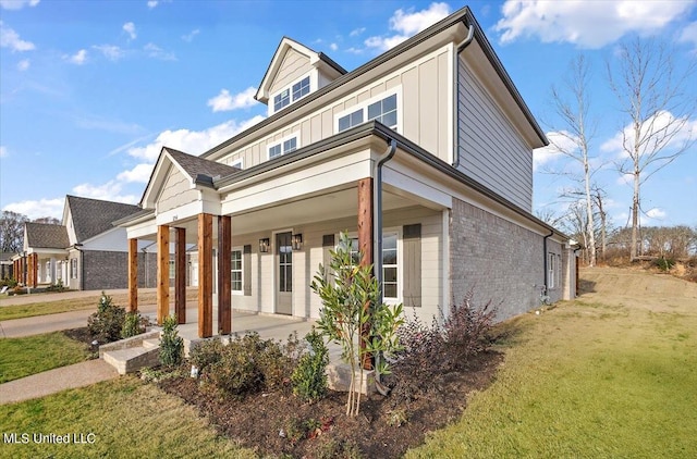 view of front of property featuring covered porch and a front lawn