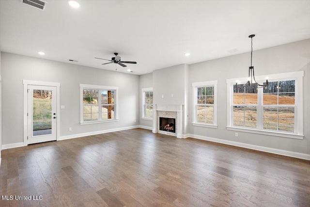 unfurnished living room with dark hardwood / wood-style flooring and ceiling fan with notable chandelier