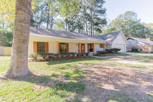 single story home featuring a porch, a front yard, and a garage