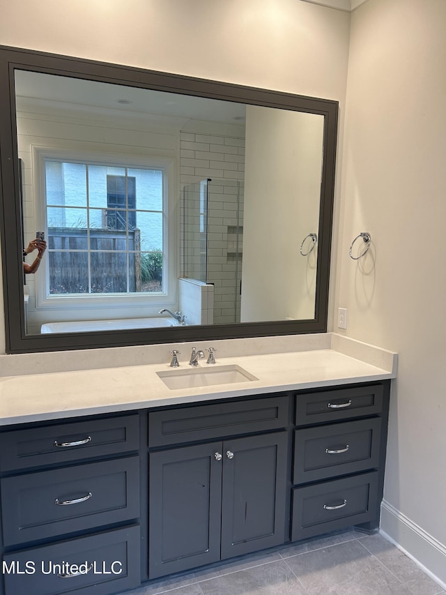 bathroom with vanity, tiled shower, and tile patterned floors