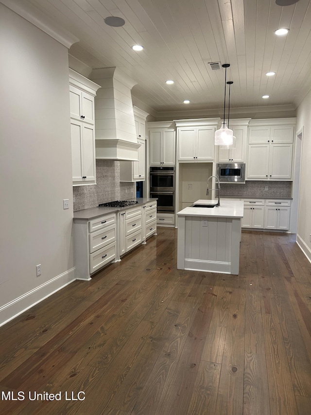 kitchen with hanging light fixtures, sink, premium range hood, appliances with stainless steel finishes, and dark hardwood / wood-style flooring