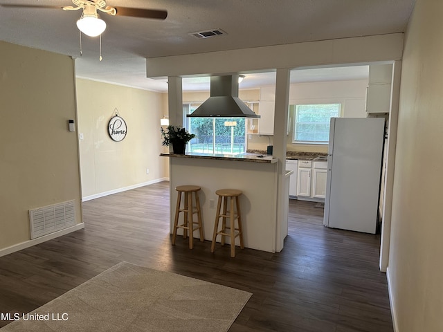 11086 E Taylor Rd, Gulfport, MS 39503 - kitchen featuring island range hood, freestanding refrigerator, a kitchen bar, white cabinets, and a ceiling fan
