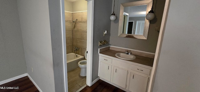 full bathroom featuring toilet, tiled shower / bath, hardwood / wood-style flooring, and vanity