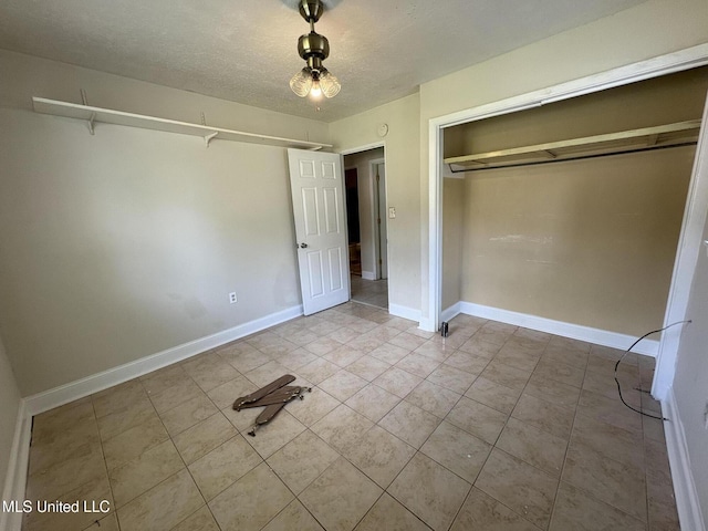3435 Casa Grande Cir, Jackson, MS 39209 - unfurnished bedroom with tile patterned flooring, a textured ceiling, a closet, and baseboards
