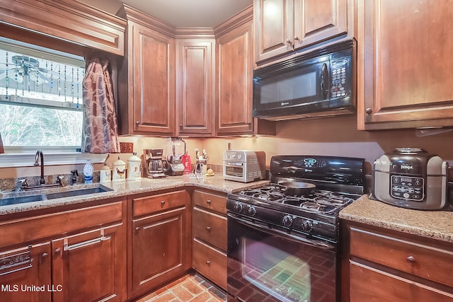 kitchen with light stone counters, sink, and black appliances