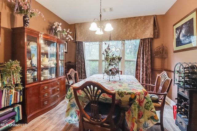 dining room featuring light wood-type flooring and a notable chandelier