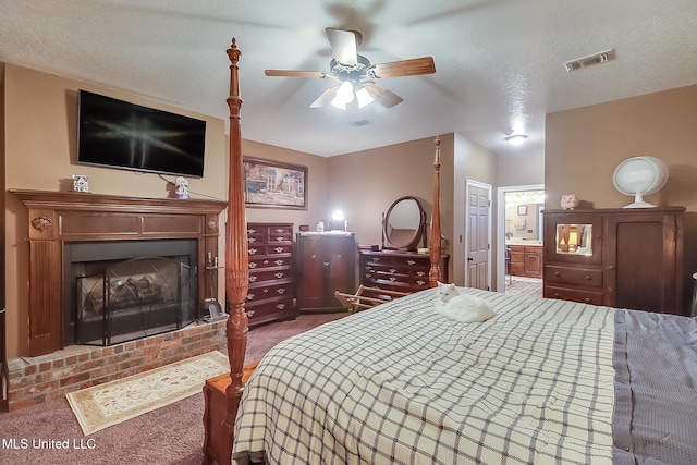 bedroom featuring ensuite bathroom, carpet flooring, ceiling fan, a fireplace, and a textured ceiling