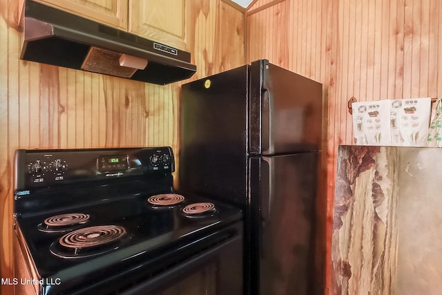 kitchen featuring black appliances, wood walls, and light brown cabinets