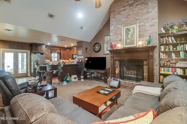 carpeted living room featuring a fireplace, french doors, high vaulted ceiling, and ceiling fan