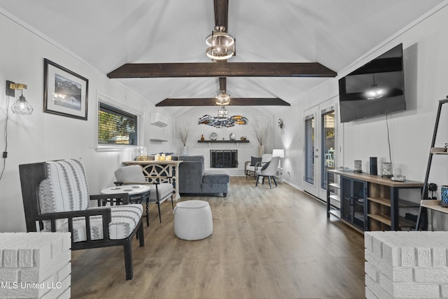 living area with a fireplace, vaulted ceiling with beams, a wall unit AC, and wood finished floors