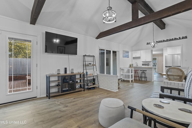 living room with high vaulted ceiling, light wood-type flooring, a notable chandelier, and beamed ceiling