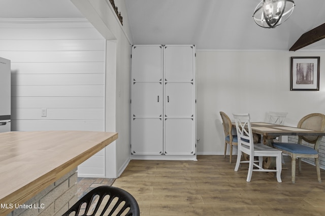 dining area featuring lofted ceiling and wood finished floors