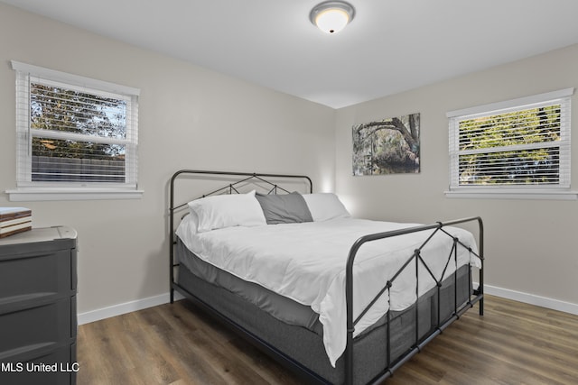 bedroom featuring baseboards and dark wood finished floors