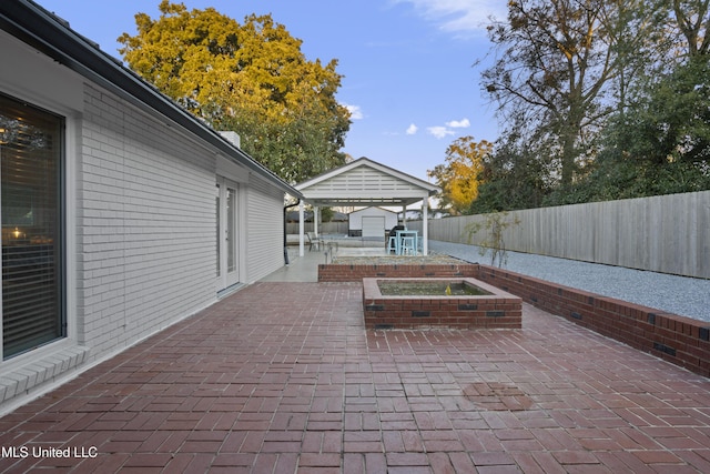 view of patio / terrace featuring an outbuilding, a storage shed, and a fenced backyard