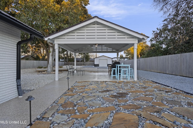 view of patio with an outbuilding, a shed, and a fenced backyard