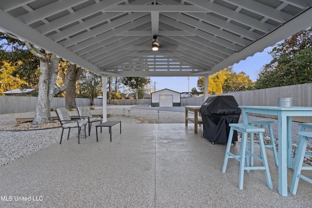 view of patio / terrace with a grill, outdoor dining area, a fenced backyard, and an outdoor structure