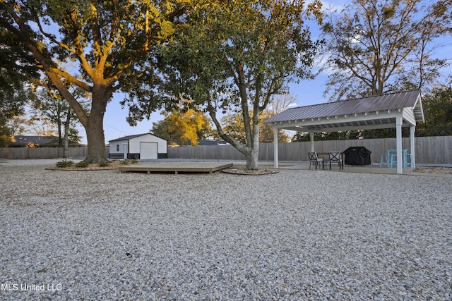 view of yard with a gazebo, an outdoor structure, a fenced backyard, and a wooden deck