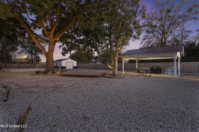 view of yard with an outbuilding, a fenced backyard, and a gazebo