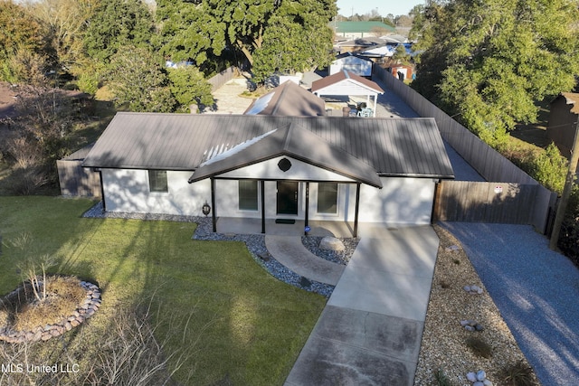 view of front of home with fence, a front lawn, and metal roof